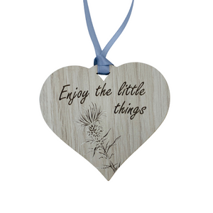 A hanging heart plaque featuring the phrase "Enjoy the Little Things"