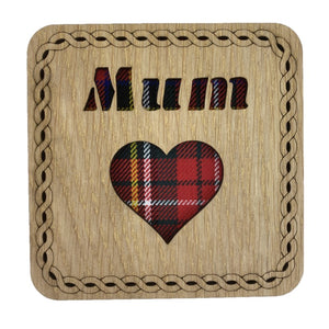 A wooden square coaster with a tartan background featuring the word "Mum" and a Heart.