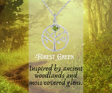 Load image into Gallery viewer, Silver tree pendant necklace with green gemstone on a forest-themed background
