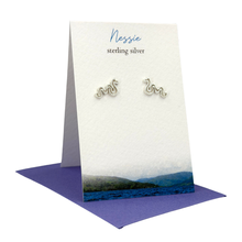 Load image into Gallery viewer, Silver 'Nessie' earrings on a branded card with a scenic design
