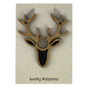 Lucky Sixpence in the centre of a stag wooden plaque and tartan background