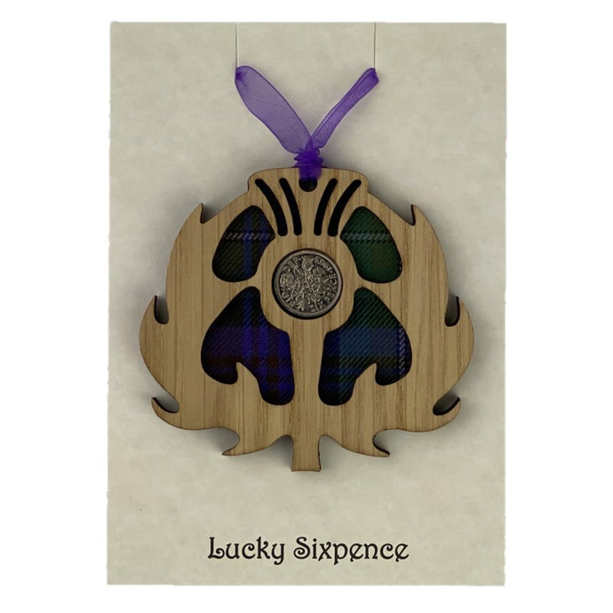 Wooden Plaque in the shape of a thistle with tartan background and lucky sixpence in the centre
